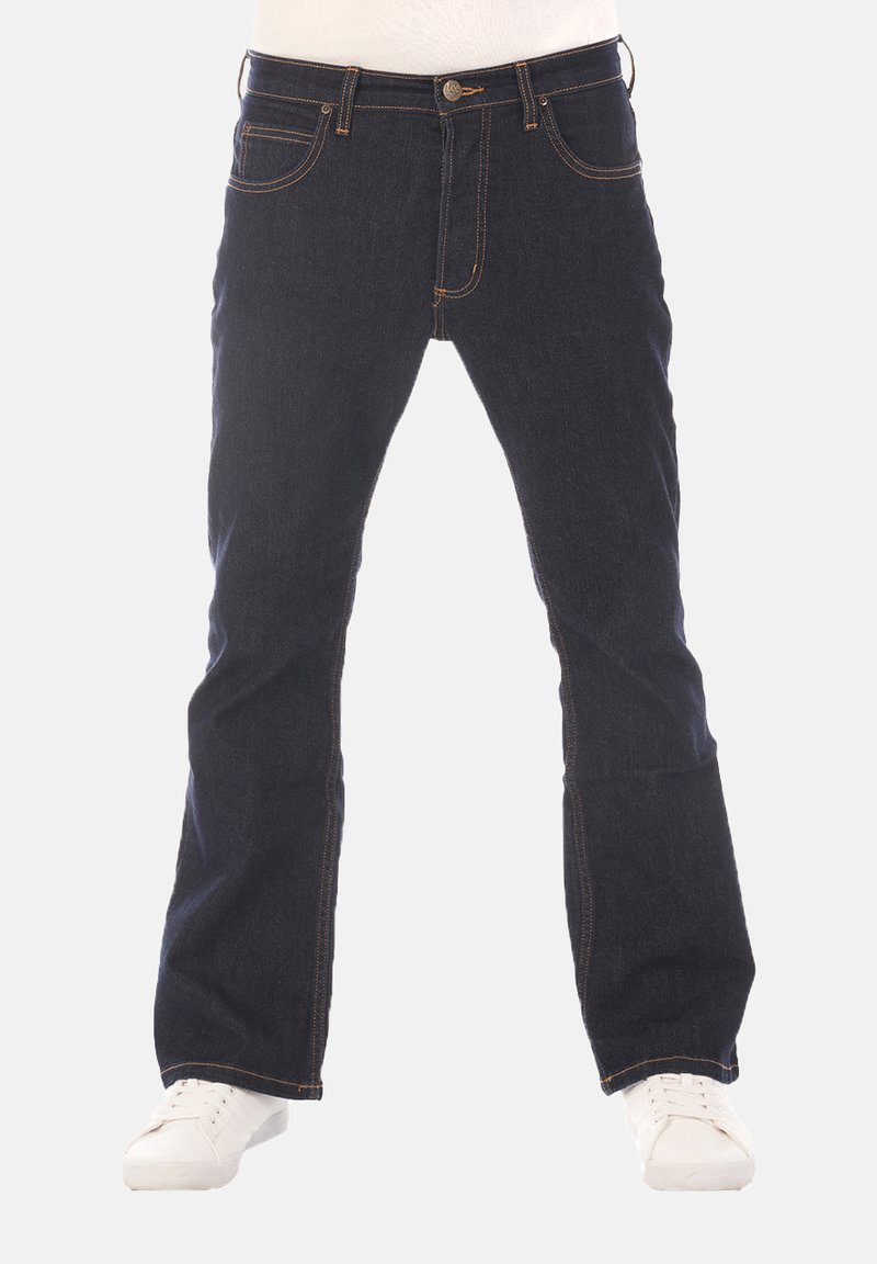 Donkerblauwe spijkerbroek met een rechte pijp, subtiele stikseldetails, vijf zakken en een ritssluiting aan de voorkant. Gecombineerd met witte sneakers.