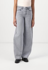Jeans a vita alta e gamba ampia in denim grigio chiaro. Caratterizzati da un classico stile a cinque tasche, dettagli di cucitura e una vestibilità rilassata.