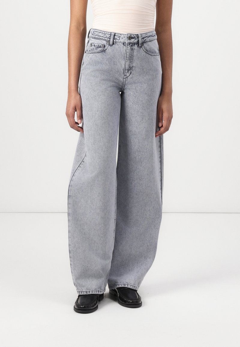 Jeans a vita alta e gamba ampia in denim grigio chiaro. Caratterizzati da un classico stile a cinque tasche, dettagli di cucitura e una vestibilità rilassata.