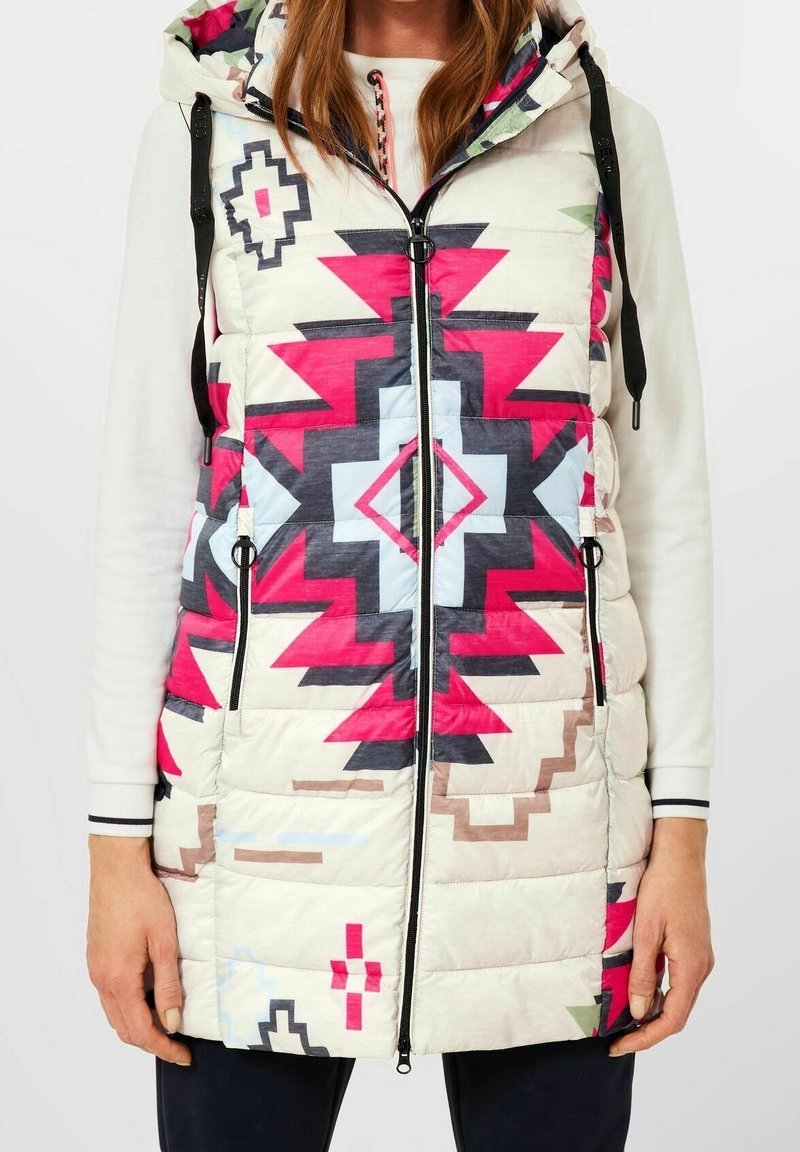 Veste matelassée avec capuche, présentant un motif géométrique en rose, bleu et beige. Poches zippées et cordons de serrage réglables pour un ajustement parfait.