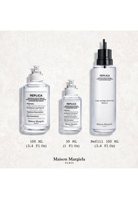 Tre klare Maison Margiela Replica-parfymeflasker merket Lazy Sunday Morning, størrelser 100 ml, 30 ml og 100 ml refill, på en lys marmorflate.