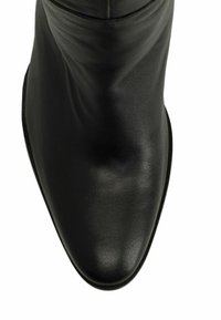 Bottine en cuir noir avec une texture lisse, un bout pointu et un design sans couture. L'empeigne présente des coutures minimales et une silhouette élancée.