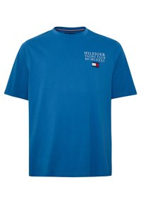 Modré bavlněné tričko s kulatým výstřihem; obsahuje nápis "HILFIGER YACHT CLUB" a malou červenou, bílou a modrou vlajkovou emblem na hrudi.