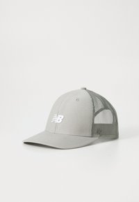 Helle graue Baseballcap mit einem Netzrücken und weißem New Balance Logo auf der Vorderseite, platziert auf einer weißen Oberfläche.