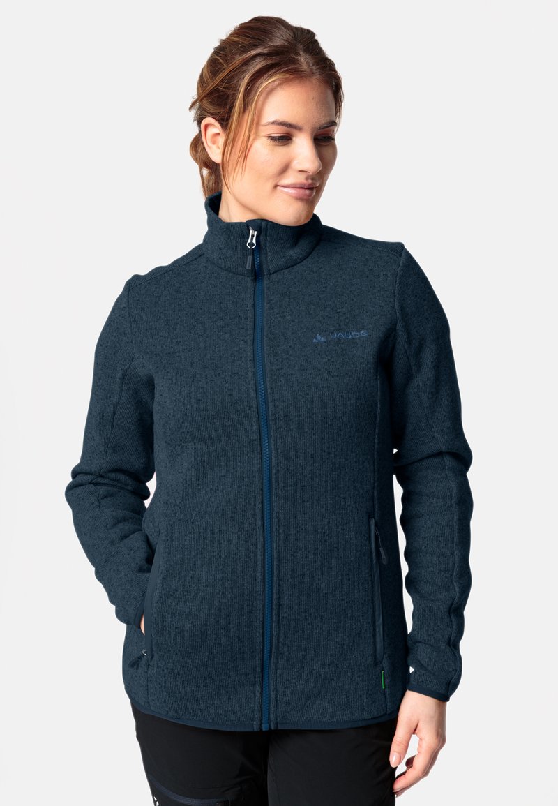 Marineblaue Fleecejacke mit hohem Kragen, durchgehendem Reißverschluss und zwei Seitentaschen. Mit strukturierter Stoffoberfläche und gesticktem Logo auf der Brust.
