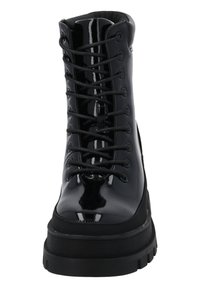 Czarne lakierowane buty wojskowe z okrągłym noskiem, sznurowanym przodem i masywną platformą. Posiadają poziome rowki na podeszwie.