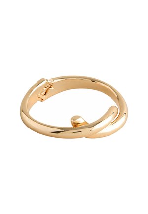 Kulta-sävyinen metallirannekoru, jossa on sileä, kiillotettu pinta. Rannekoru on kierretty muotoilultaan ja siinä on turvallinen lukitusmekanismi.