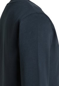 Camicia a maniche lunghe blu navy con scollatura rotonda, realizzata in un tessuto morbido e liscio, con un design aderente e cuciture minime.