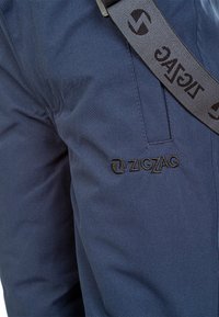 Pantaloni in tessuto blu navy con finitura testurizzata, con logo "ZIGZAG" ricamato in nero e una fascia in contrasto con branding "ZIGZAG".
