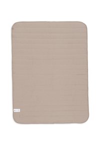 Couverture carrée beige matelassée avec des coins arrondis et une petite étiquette blanche dans le coin inférieur gauche, sur un fond blanc.