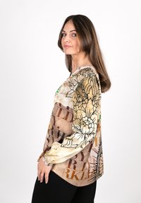 Langärmlige Bluse mit floralem und textlichem Muster in Braun, Beige und Grün. Verfügt über einen runden Ausschnitt und eine lockere Passform. Glatte Stoffstruktur.