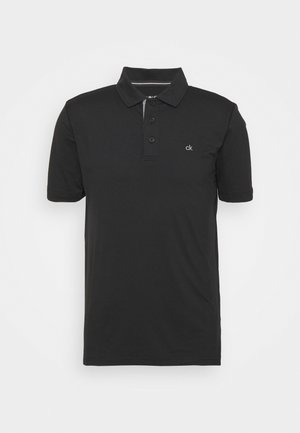 Juodos polo marškiniai, pagaminti iš medvilnės mišinio, su klasikiniu apykakle, trijų mygtukų užsegimu ir mažuoju logotipu ant krūtinės. Trumpomis rankovėmis.