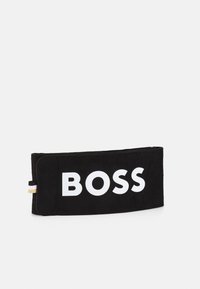 Monedero negro con una textura suave, con un audaz texto blanco "BOSS" en la parte frontal y pequeños detalles de acento coloridos en el lateral.