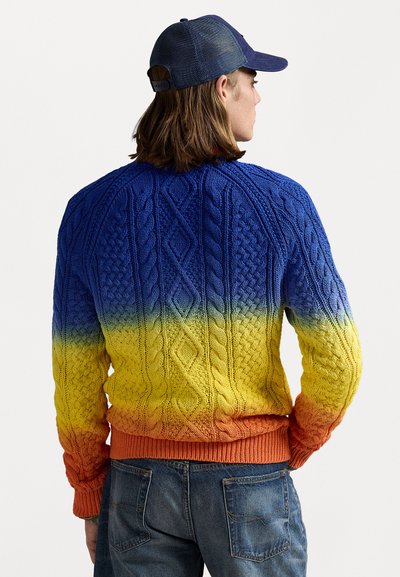 Strikket sweater med en livlig gradient fra blå til gul og orange, med kabelstrik mønstre og ribbenede manchetter og kant. Casual design.