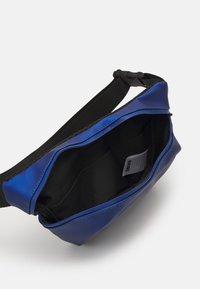 Niebieska torba o matowym wykończeniu z czarnym wnętrzem. Posiada zapięcie na suwak oraz regulowany pasek. Zawiera kieszenie wewnętrzne do organizacji.
