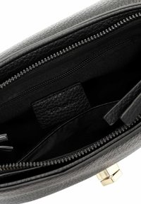 Interno di una borsa nera a trama con chiusura a zip, fodera in tessuto, una tasca piccola e accessori in tono oro.