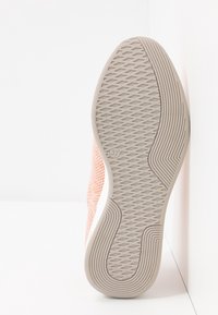 Korálové síťované tenisky s texturovanou béžovou gumovou podrážkou s cik-cak vzorem a zaobleným podpatkem. Velikost vyznačená jako 37 na podrážce.