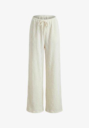 Pantalon large blanc texturé et confortable avec taille élastique et cordon de serrage, adapté pour une tenue décontractée.