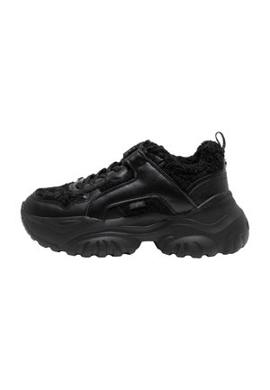 Sneaker nera massiccia con suola spessa e testurizzata, chiusura con lacci davanti e bordo in ecopelliccia intorno al collo e alla linguetta, vista laterale.