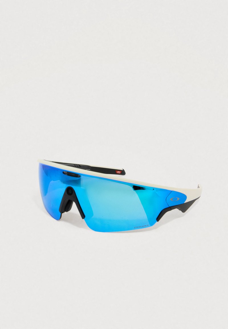 Gafas de sol deportivas con lentes tintados en azul, montura blanca, detalles negros y un diseño envolvente para mayor protección y visibilidad.