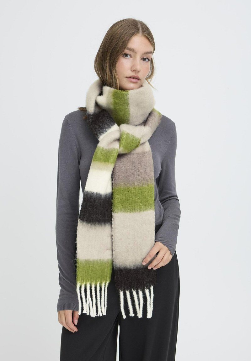 Écharpe en laine avec des rayures alternées vertes, beiges, noires et blanches ; présente une longue frange d'un côté ; texture douce.