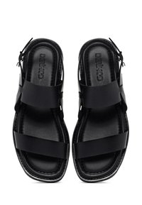 Black sandals feature a sleek design with wide straps and a textured sole. Open back and toe area enhance breathability and comfort.