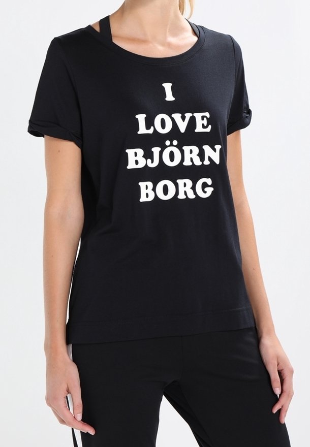 Camiseta de algodón negra con mangas enrolladas y texto blanco que dice "ME ENCANTA BJÖRN BORG". Corte recto, textura suave, diseño minimalista.