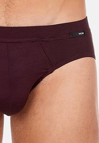 Burgunderfarbene Herrenunterhosen aus weichem Stoff mit einem tief sitzenden Design, elastischem Bund und dezentem Logodetail auf der Vorderseite.