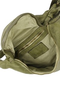Groene leren handtas interieur met een ritsvak, gevoerde stof en een label met de tekst "Venezia Genuine Leather".