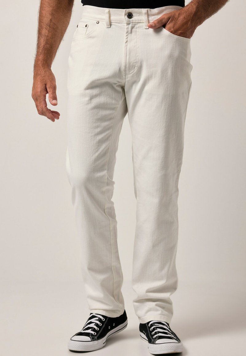 Pantalones de mezclilla blancos de corte recto, con cierre de botón y cremallera, bolsillos frontales y un acabado texturizado sutil, combinados con zapatillas negras.