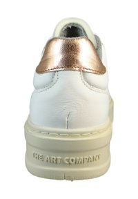 Białe skórzane sneakersy z metalicznym różowym akcentem na pięcie, teksturowaną powierzchnią i gumową podeszwą, z logo na pięcie.