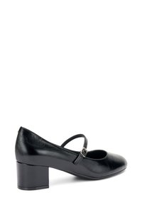 Zapato bajo de cuero negro con tacón bajo, puntera redonda, correa ajustable en el tobillo y un acabado texturizado en la parte superior.