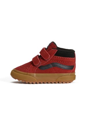 Czerwony dziecięcy sneaker za kostkę z czarnym paskiem, czarnym wyściełanym kołnierzem, dwoma paskami na rzepy oraz brązową gumową podeszwą.