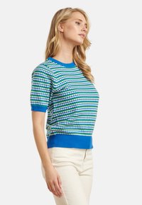 Korte mouwen gebreide trui met een gestreept patroon in blauw, groen en wit. Ribgebreide ronde hals en zoom, zachte textuur, casual pasvorm.