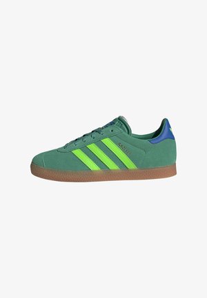 Green suede sneakers featuring neon green stripes, rubber gum sole, and blue accents on the heel; designed in a classic low-top silhouette.