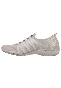 Chaussure de sport gris clair avec tige en tissu flexible, lacets en toile élastique et talon texturé, dotée d'une semelle en caoutchouc moulé pour une meilleure adhérence.