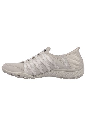 Light grey athletic shoe featuring flexible fabric upper, elastic webbing lacing, and textured heel, with a molded rubber sole for traction.