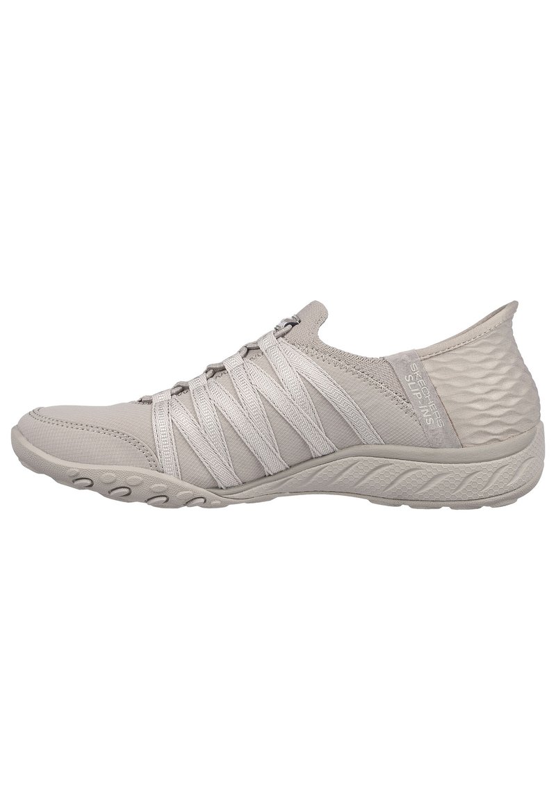 Chaussure de sport gris clair avec tige en tissu flexible, lacets en toile élastique et talon texturé, dotée d'une semelle en caoutchouc moulé pour une meilleure adhérence.
