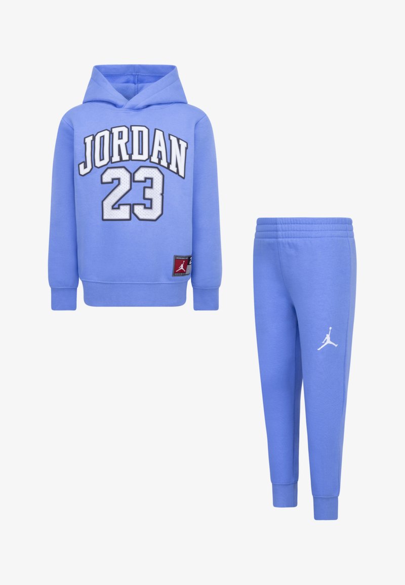 Svijetloplavi dukserica s kapuljačom na kojem piše "JORDAN 23" bijelim i crnim slovima; uparen s trenirkom s bijelim Jordan logom; oboje od mekog materijala.