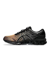 Chaussures de sport avec un design dégradé passant de l'orange au noir, tige en maille, lacets noirs et une semelle noire texturée avec des picots proéminents.