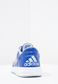 Blå lädersportskor med vit gummisula, utrustad med vita ränder och logotyp. Designad med vadderad krage och tunga.