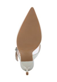 Chaussure à talons hauts blanche avec un bout pointu et des côtés transparents. Elle est dotée d'une semelle en caoutchouc beige et d'une finition en boucle argentée.