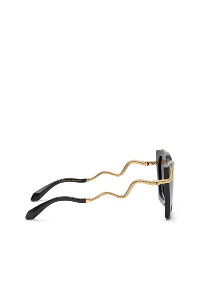 Lunettes de soleil rectangulaires noires avec des branches incurvées dorées à motif serpent et des embouts de branches noirs, vues de profil sur fond blanc.