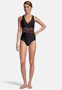 Maillot de bain une pièce noir avec un décolleté en V, présentant une section centrale à motif coloré et des bretelles réglables. Tissu lisse et extensible.