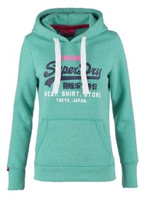 Felpa verde realizzata in morbido tessuto, con tasca frontale, cordini bianchi e testo stampato in blu navy e rosa.