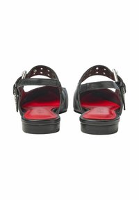 Svarta lädersandaler med en slät textur, öppen häl och röda innersulor. Utrustade med ett spänne och flera hål för storleksjustering.