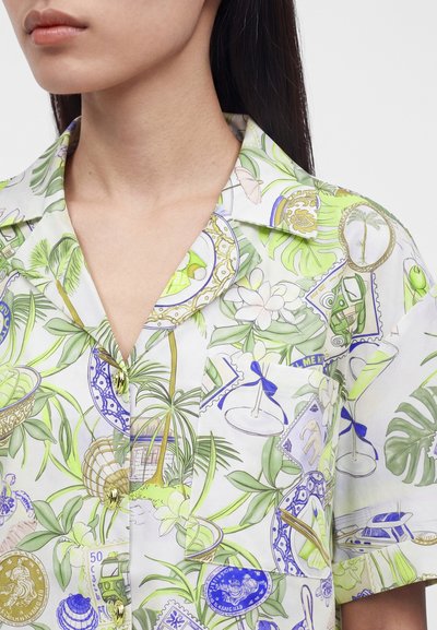 Πουκάμισο με γιακά με τροπικά πράσινα φύλλα, φοίνικες, λουλούδια, γραμματόσημα και vintage εικονογραφήσεις με θέμα τα ταξίδια σε λευκό φόντο.