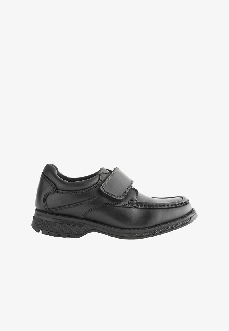 Chaussure en cuir noir avec une bande Velcro, bout arrondi et semelle en caoutchouc texturé. Présente des coutures sur les côtés pour une durabilité accrue.