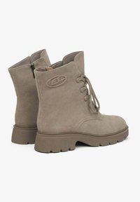 Kawowe zamszowe botki za kostkę z sznurowanym przodem, bocznym zamkiem, grubą teksturowaną podeszwą oraz wytłoczonym detalem logo po boku.