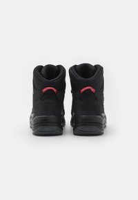 Czarne półwysokie sneakersy wykonane z gładkich i teksturowanych materiałów. Posiadają wyściełany kołnierz, czerwone logo na pięcie oraz solidną gumową podeszwę.